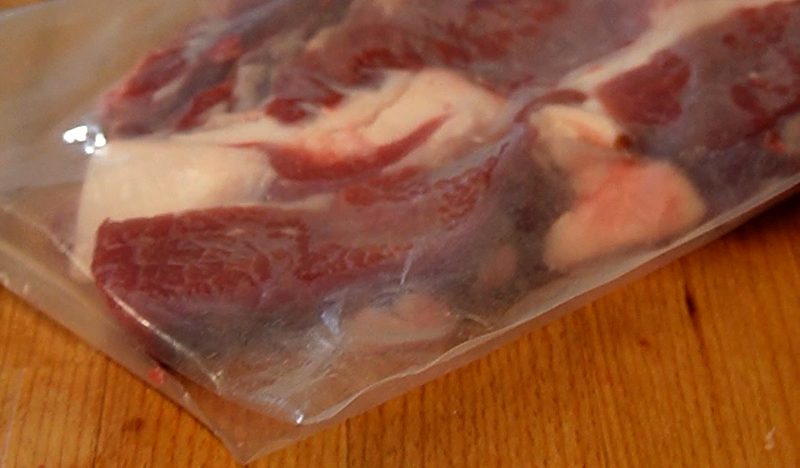 La bolsa ya cerrada con los cortes dentro, en reposo sobre la tabla del mostrador.