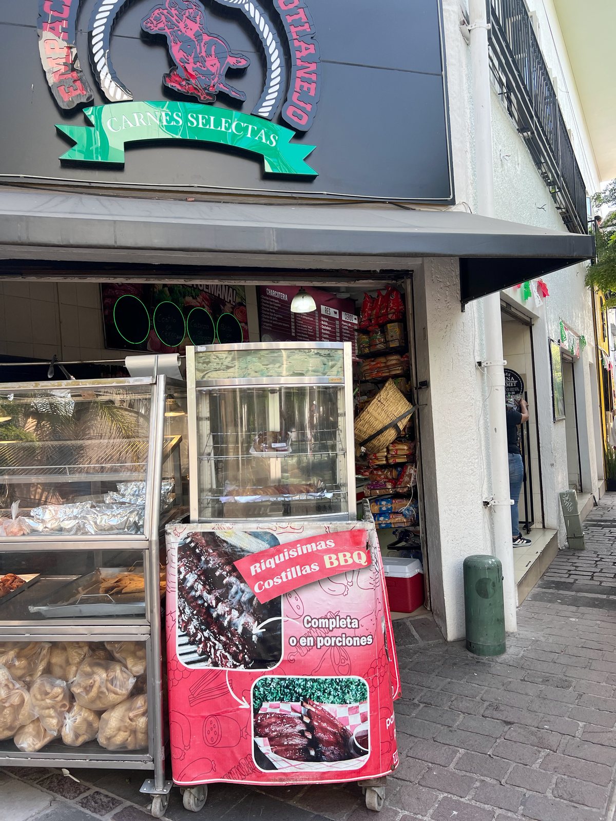 La fachada de El Rodeo en Zapotlanejo: el letrero con el sello y la banda «Carnes selectas», el toldo y, debajo, la entrada con las vitrinas.